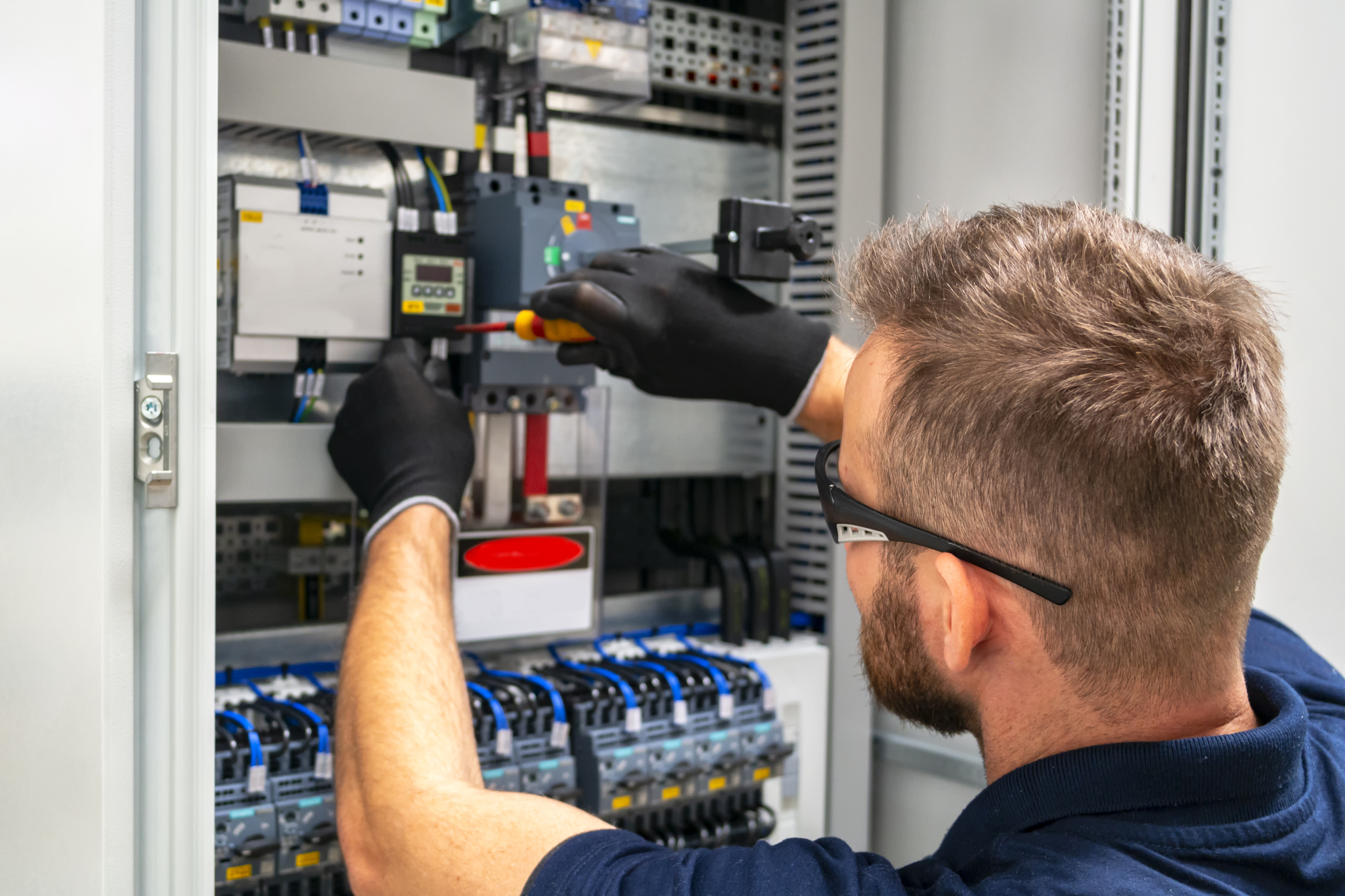 Electrician rewiring a fuse board